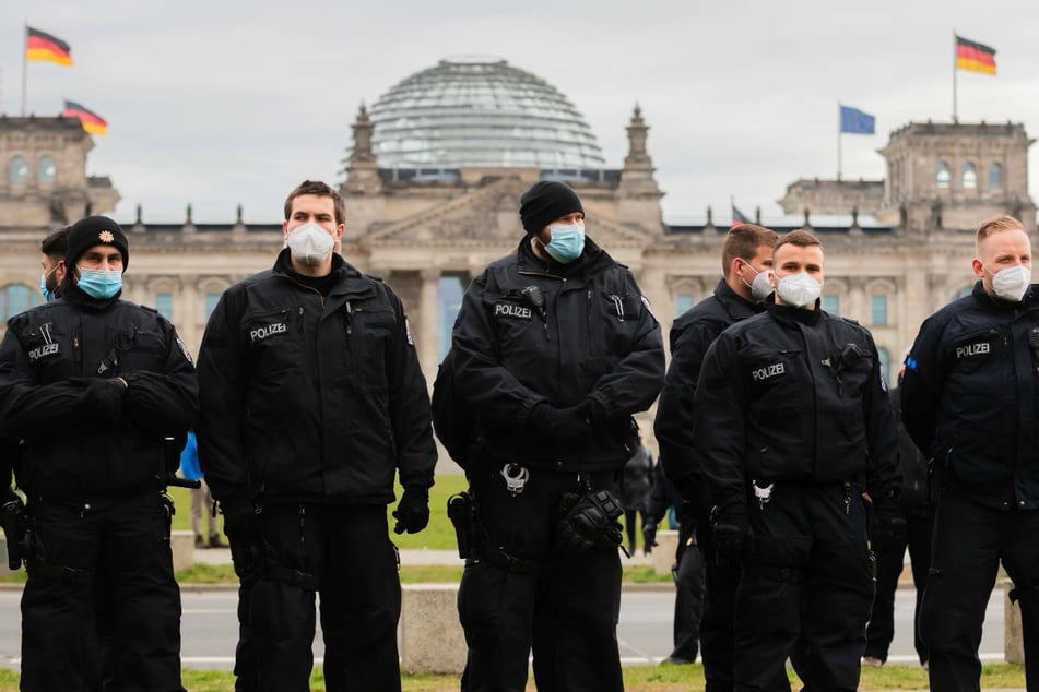 Polizisten stehen bei einer Kundgebung gegen die Corona-Maßnahmen vor dem Reichstagsgebäude. Auch am Mittwoch sind in Berlin mehrere Demonstrationen wegen der Abstimmung über das geänderte Infektionsschutzgesetz geplant.