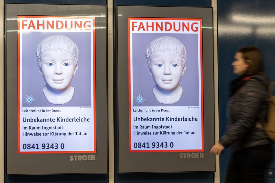 Eine Frau geht am Münchner Ostbahnhof an einem digitalen Fahndungsplakat vorbei. Mehr als ein halbes Jahr nach dem Fund der Kinderleiche setzt die Kripo auf die Zusammenarbeit mit dem Bundeskriminalamt (BKA).