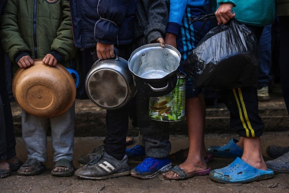 Displaced Palestinian children wait in line to receive food at a distribution centre in Deir el-Balah in the central Gaza Strip on November 26, 2024.