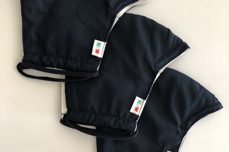 Die Masken sind passend zur Uniform dunkelblau und haben einen kleinen "NRW"-Schriftzug.