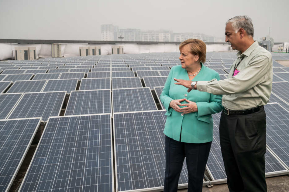 Angela Merkel besichtigt die mit Solarenergie betriebene Metrostation Dwarka Sector 21 und lässt sich im Rahmen des Besuchs den Betrieb von elektrisch angetriebenen e-Rikschas erklären.