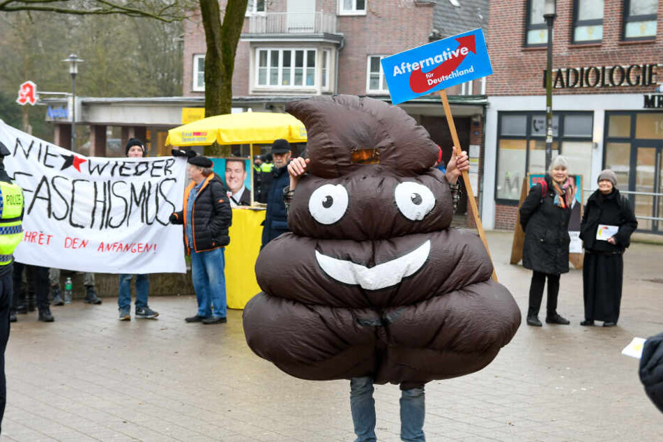Was dieser Demonstrant von der AfD hält, macht er durch den Kothaufen-Emoji deutlich sichtbar.