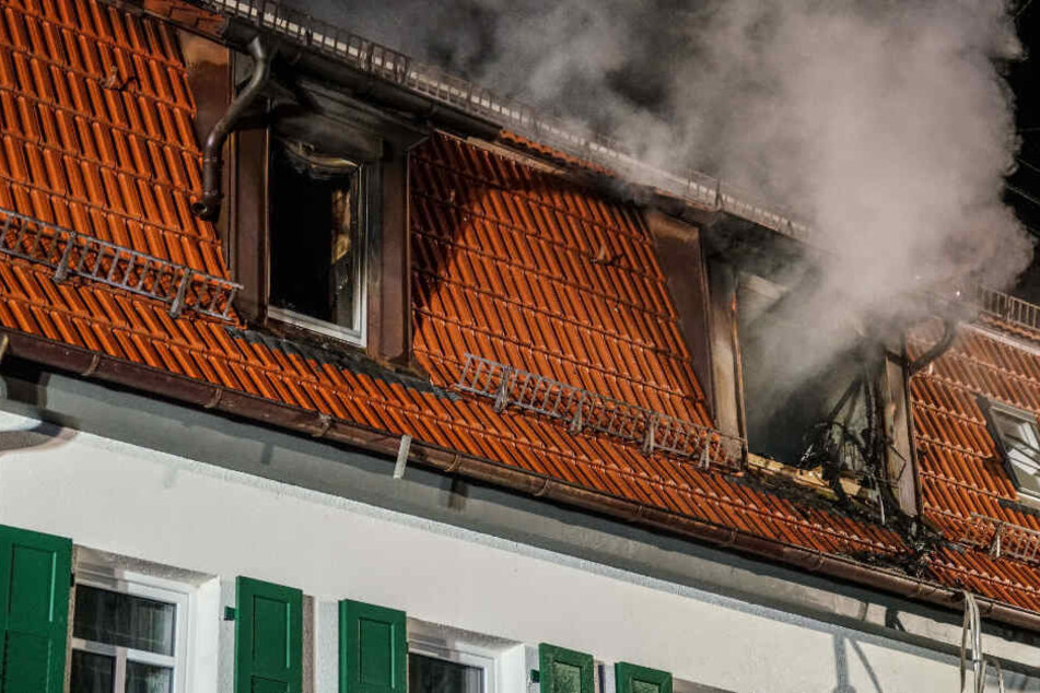 Rauch steigt aus zwei Fenstern einer Asylunterkunft auf.