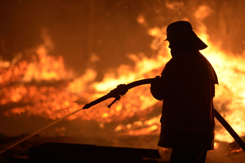 Ein Feuerwehrmann löscht einen Brand (Symbolbild).