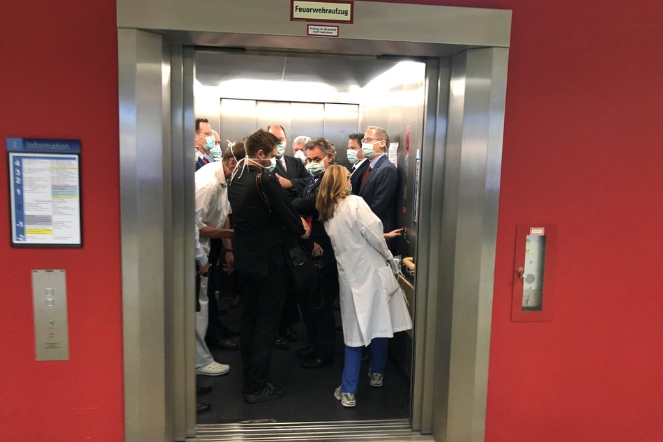 Bei einem Besuch der Uniklinik Gießen drängen sich Bundesgesundheitsminister Jens Spahn (CDU, l), und Hessens Ministerpräsident Volker Bouffier (CDU, M) mit Begleitern in einem Fahrstuhl.