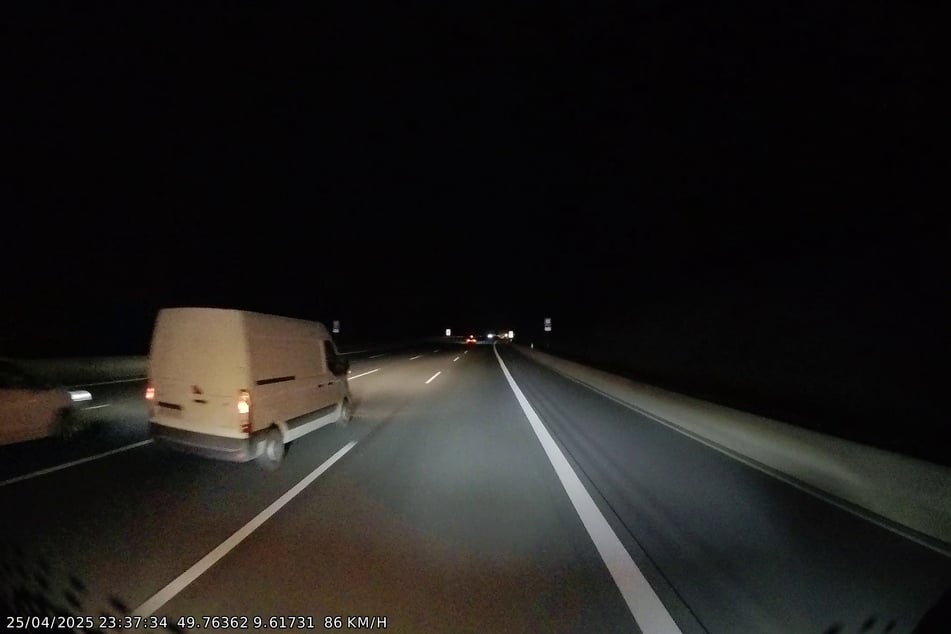 Nachdem dieser weiße Transporter auf die rechte Fahrspur wechselt, erfasst er den Fahrer eines Pannenfahrzeugs.
