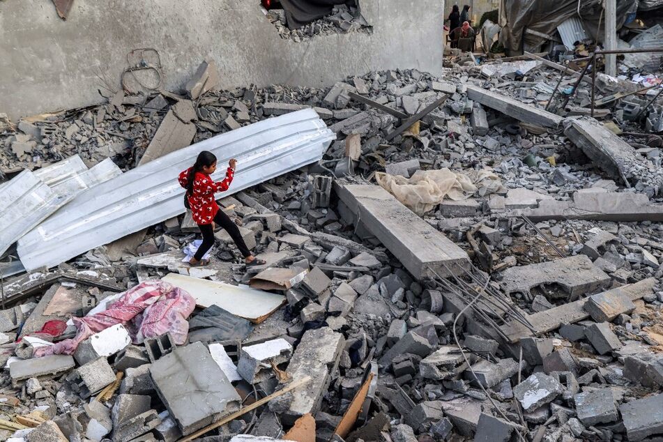 A Palestinian girl walks through rubble in Rafah in the southern Gaza Strip on April 24, 2024, following overnight Israeli airstrikes.