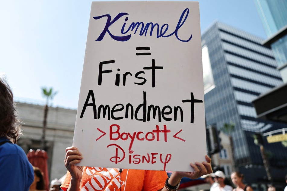 A demonstrator raises a sign in support of free speech rights during a protest against the suspension of the Jimmy Kimmel Live! show in Los Angeles, California, on September 22, 2025.