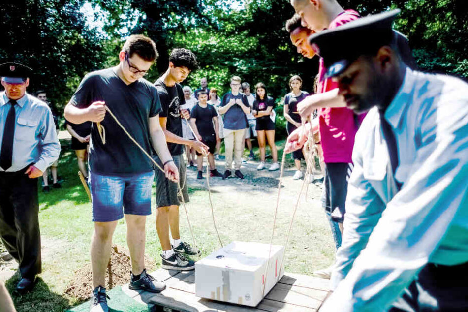 Schüler beerdigen in Düsseldorf in einem Pappkarton ein Skelett.
