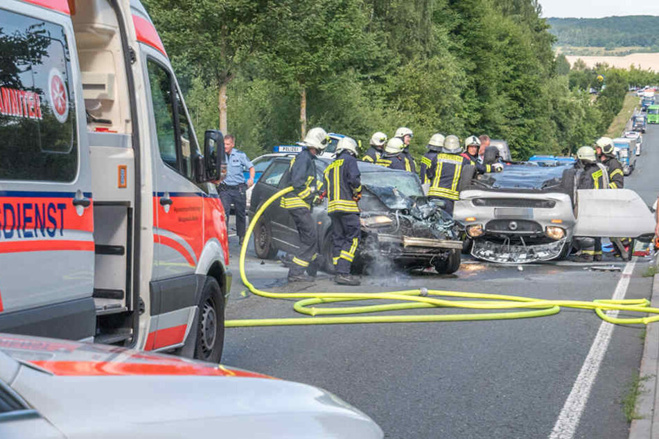 Einsatzkräfte versuchen die eingeklemmten Fahrer aus ihren Fahrzeugen zu schneiden.