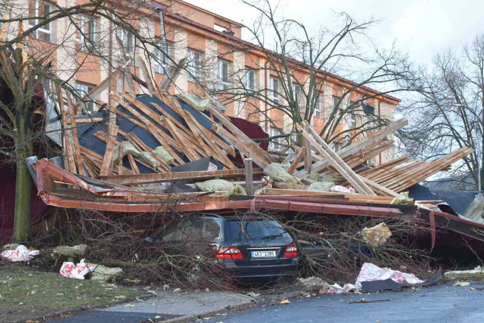 Ein Auto steckt unter den Trümmern fest, nachdem ein starker Wind durch die Stadt geweht ist.