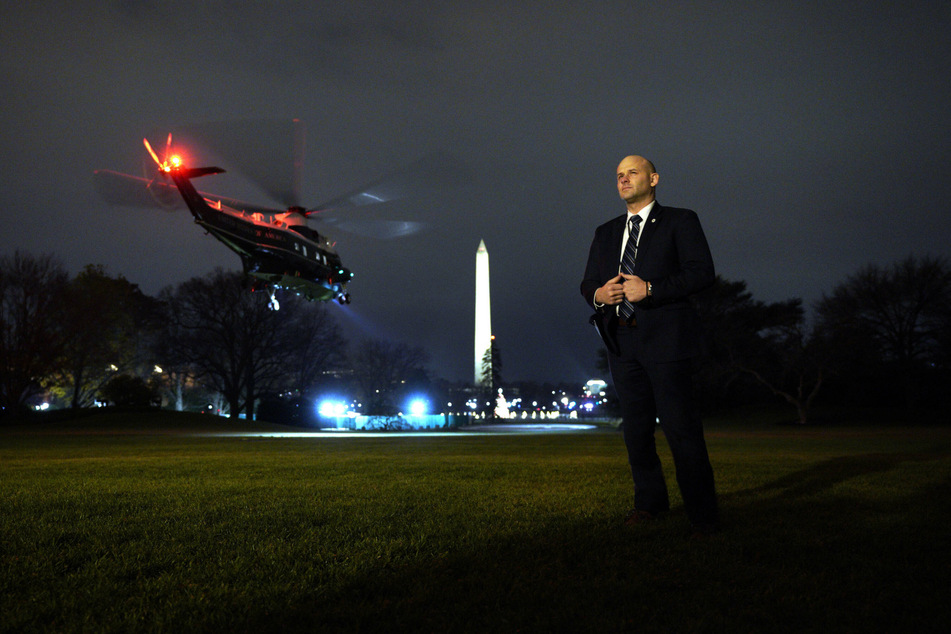 A Secret Service agent stands guard as the Marine One helicopter takes off.