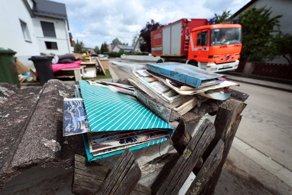 Vom Hochwasser zerstörte Fotoalben liegen vor einem Wohnhaus in Baar-Ebenhausen.