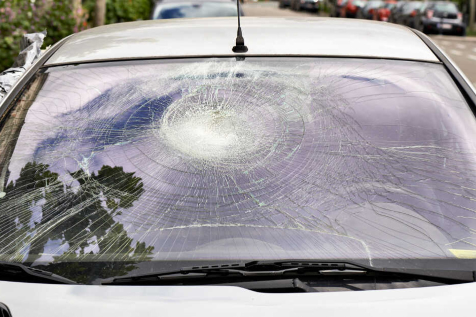 Die Windschutzscheibe eines Autos wurde von einem Steinbrocken zerstört. (Symbolbild)