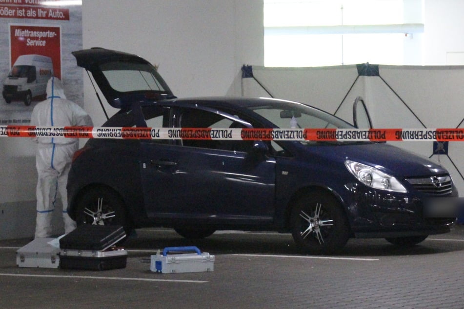 Ein Mitarbeiter der Spurensicherung arbeitet am Opel Corsa, in dessen Kofferraum die Leiche entdeckt wurde.