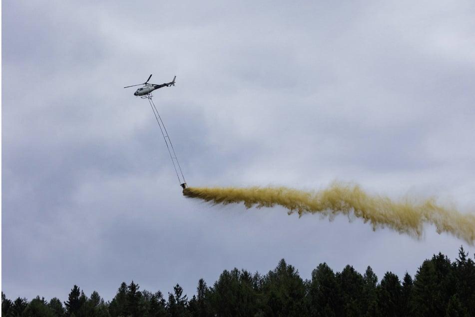 Vorsicht! Hubschrauber fliegen über ausgesuchte Waldgebiete und entladen Magnesiumkalk zur Bodenverbesserung.