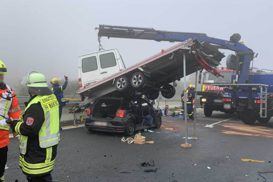 Ein Anhänger wird mit Hilfe eines Krans von einem Fahrzeug gehievt.