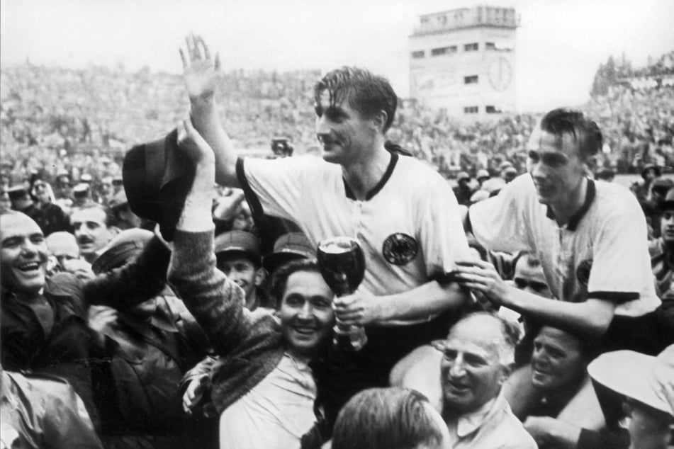 Kapitän Fritz Walter (Mitte, oben) und Teamgefährte Horst Eckel (re.) nach dem Triumph im Fußball-WM-Finale 1954.