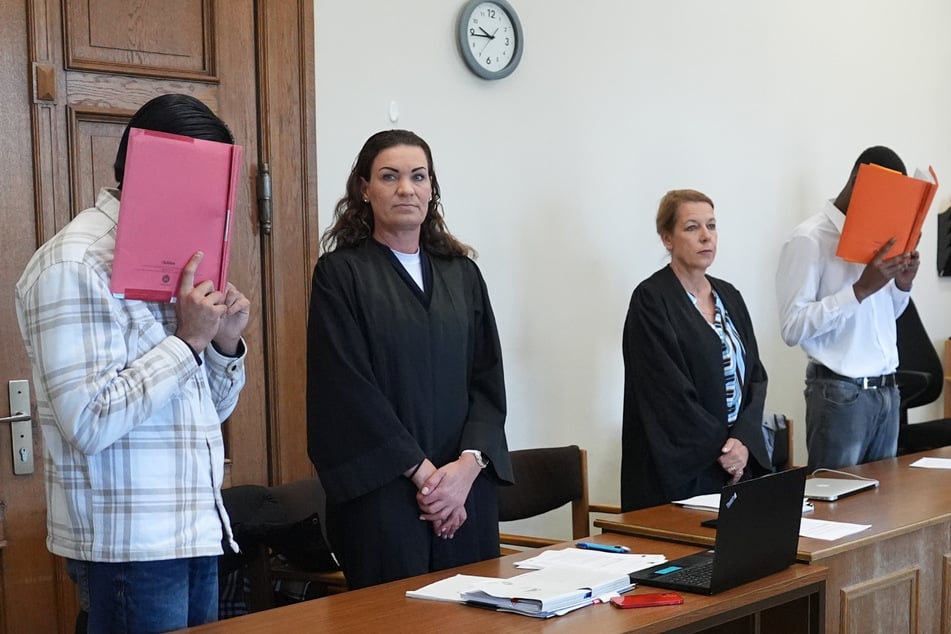 Die beiden Angeklagten (l. und r.) stehen zu Beginn des Mordprozesses neben ihren Verteidigerinnen Svenja Gruhnwald (2.v.l.) und Andrea Anisic (2.v.r.).