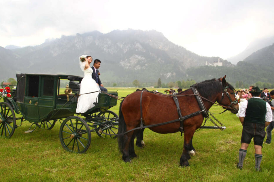 Ein chinesisches Brautpaar posiert vor dem Schloss Neuschwanstein. (Symbolbild)