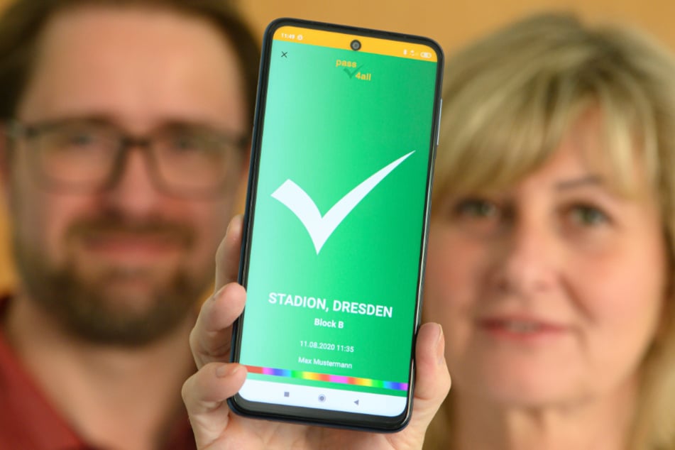 Dresden: Kathleen Parma und Jörg Meißner, Entwickler vom sächsischen Startup "pass4all", halten ein Smartphone mit der App-basierten Lösung zur anonymen Kontaktnachverfolgung mit verifizierten Kontaktdaten in den Händen.