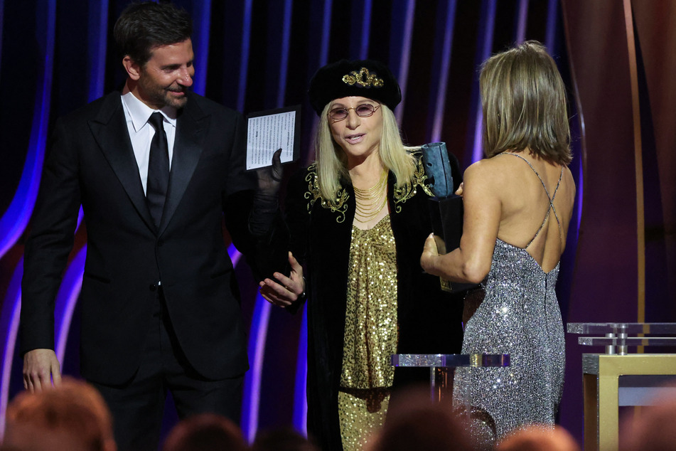 Bradley Cooper (l.) and Jennifer Aniston (r.) present the SAG Life Achievement Award to Barbra Streisand during the 30th Screen Actors Guild Awards.