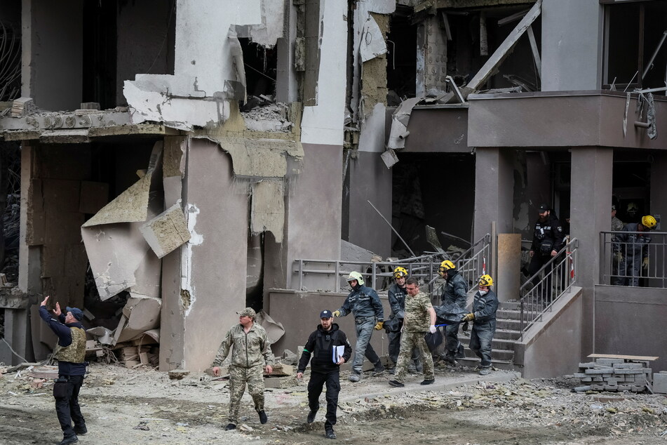 The body of Vira Hyrych, a journalist working for the US-funded Radio Free Europe/Radio Liberty, being carried out of a ruined building in Kyiv.