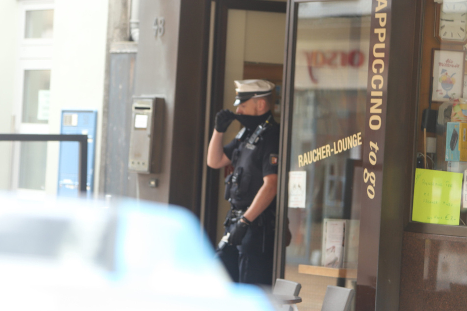Ein Polizist steht vor dem Eiscafé in der Königstraße.