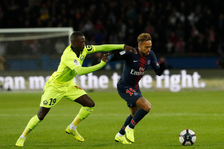 Nicolas Pépé (l) kämpft mit Neymar um den Ball.
