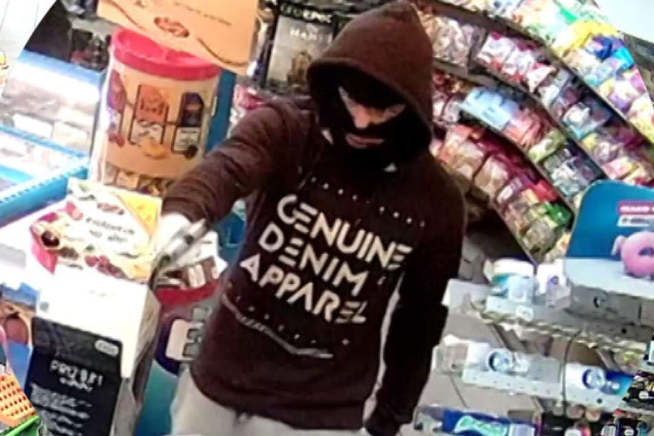 Der Mann im braunen Pullover bedrohte die Angestellte mit einer Waffe.