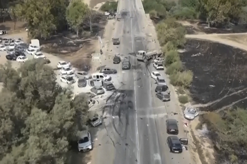Verkohlte und beschädigte Autos stehen entlang einer Straße in der Negev-Wüste. Beim Angriff von Hamas-Terroristen auf das "Tribe of Nova Trance Musikfestival" in der Nähe des Kibbutz Re'im im Süden Israels wurden mindestens 260 Menschen getötet.