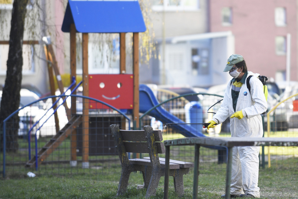 Ein Arbeiter desinfiziert eine Parkbank in Košice.