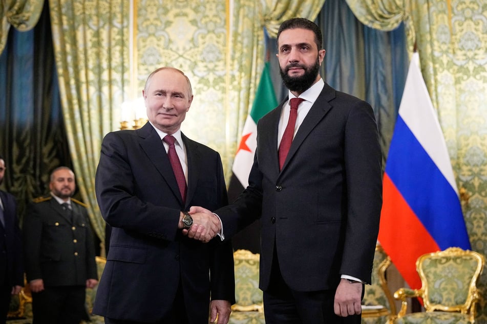 Russian President Vladimir Putin (l) and Syrian interim president Ahmed al-Sharaa (r) shake hands during their meeting at the Grand Kremlin Palace in Moscow on October 15, 2025.