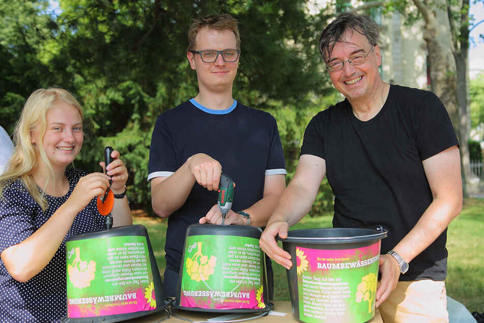 Henriette Mehn (22), Valentin Lippmann (28) und Dietrich Herrmann (56, alle Grüne) bohren je ein Loch in die Eimer.