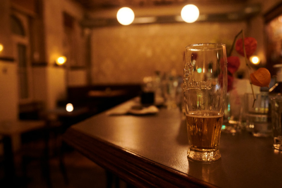 Ein halb geleertes Bier und andere benutzte Gläser stehen kurz nach der Sperrstunde in einer Bar in Neukölln auf dem Tresen.