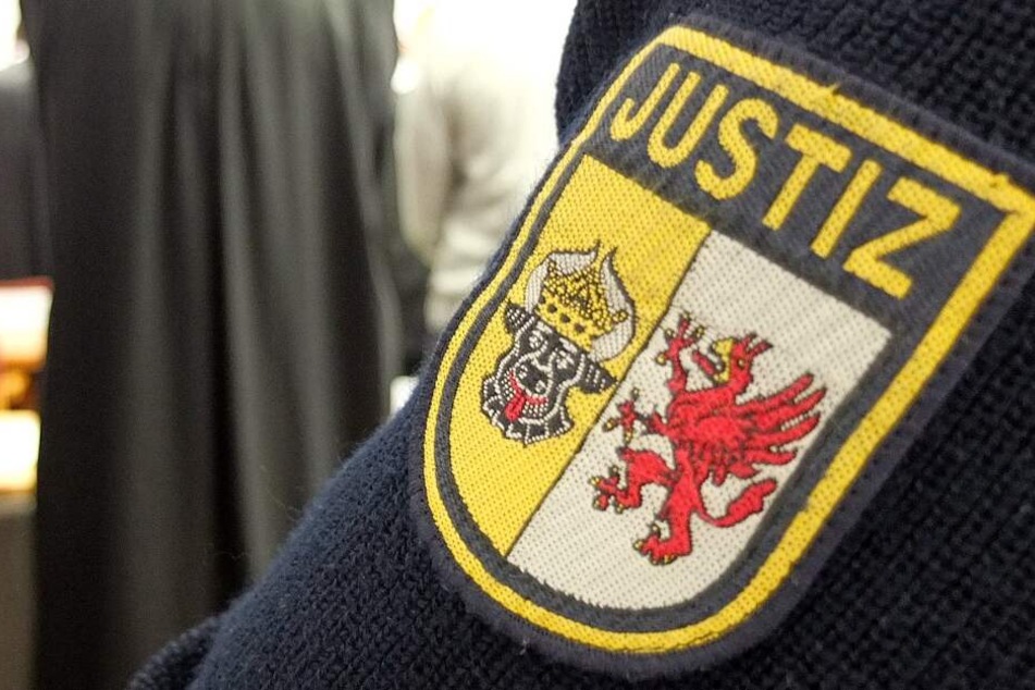 Ein Justizbeamter steht im Sitzungssaal im Landgericht.