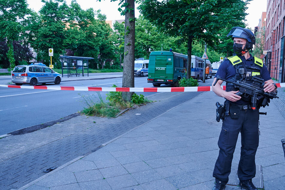 Ein schwer bewaffneter Polizist steht vor einer Absperrung in der Oranienstraße.