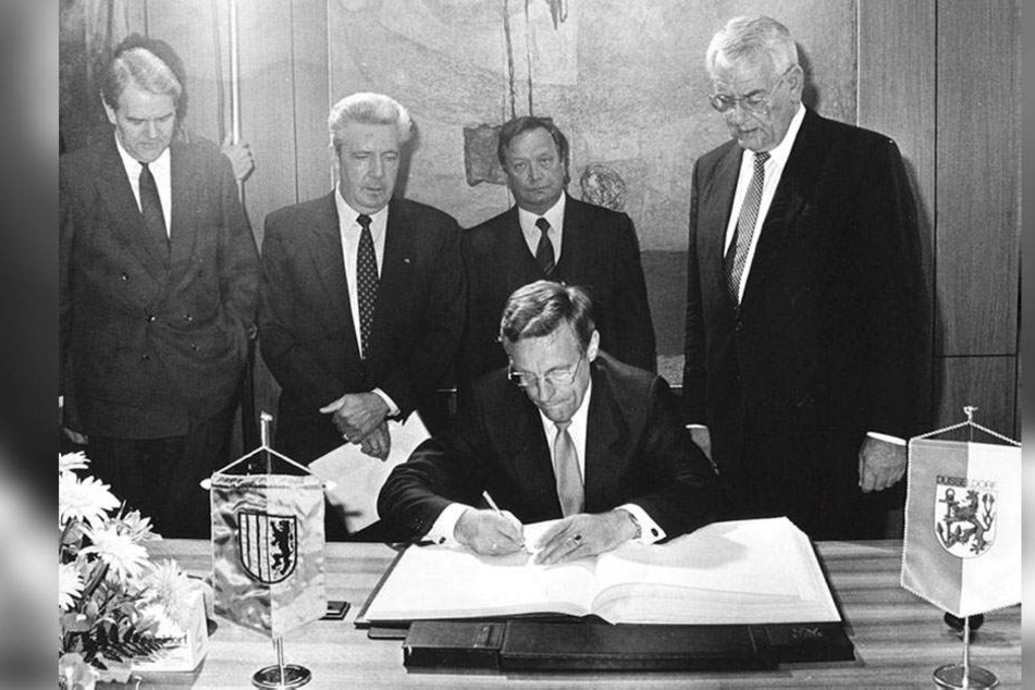Historischer Moment: Am 1. Juni 1988 besiegelten der Karl-Marx-Städter OB Eberhard Langer (sitzend) und sein Düsseldorfer Kollege OB Klaus Bungert (r.) die Städtepartnerschaft.