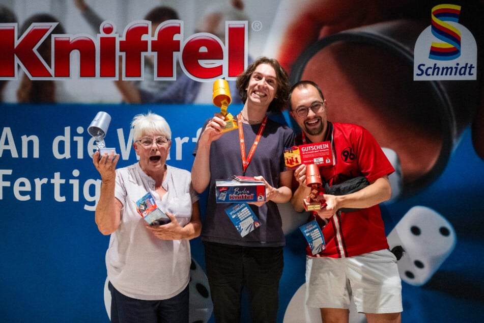 Katharina Lehmann (2. Platz, v.l.n.r.), Lennart Fiedler (1. Platz) und Nico Richard (3. Platz) jubeln nach dem Finale bei der Deutschen Kniffel-Meisterschaft.