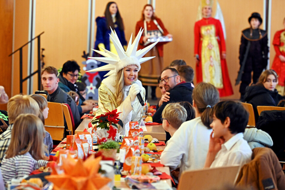 Das Sternenkind singt an der festlich gedeckten Rathaustafel für die Kinder.