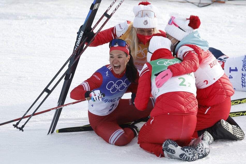 Veronika Stepanova (l.) freut sich mit dem russischen Team über die Staffel-Goldmedaille 2022 in Peking.