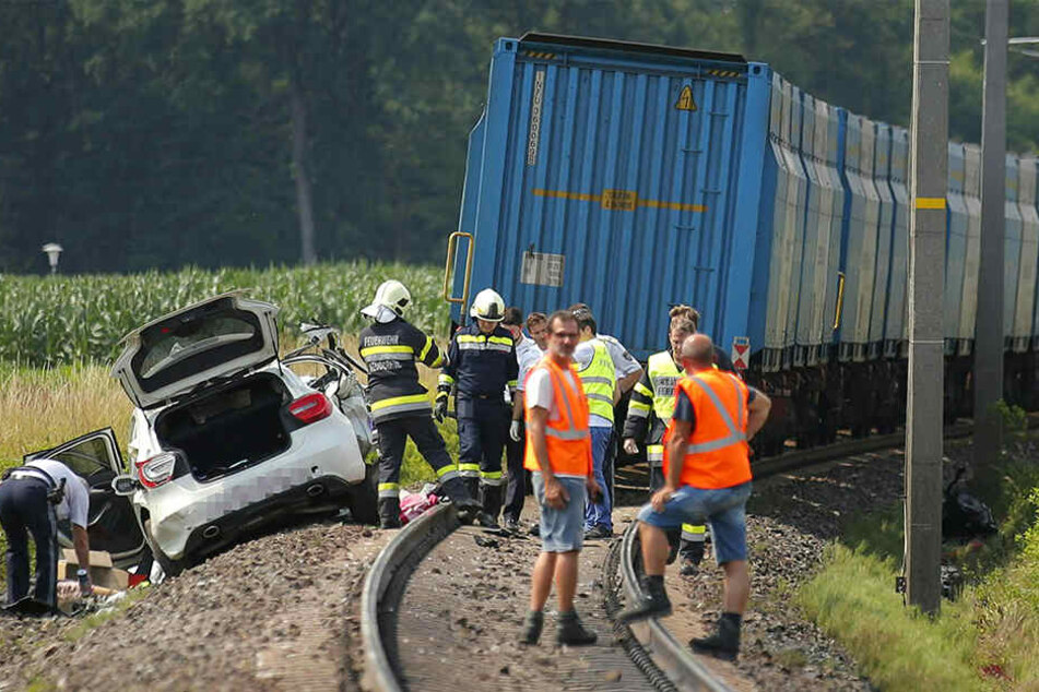 Rettungskräfte stehen am Unfallort. Bei dem Crash wurden der Fahrer des Autos sowie seine Beifahrerin tödlich verletzt.