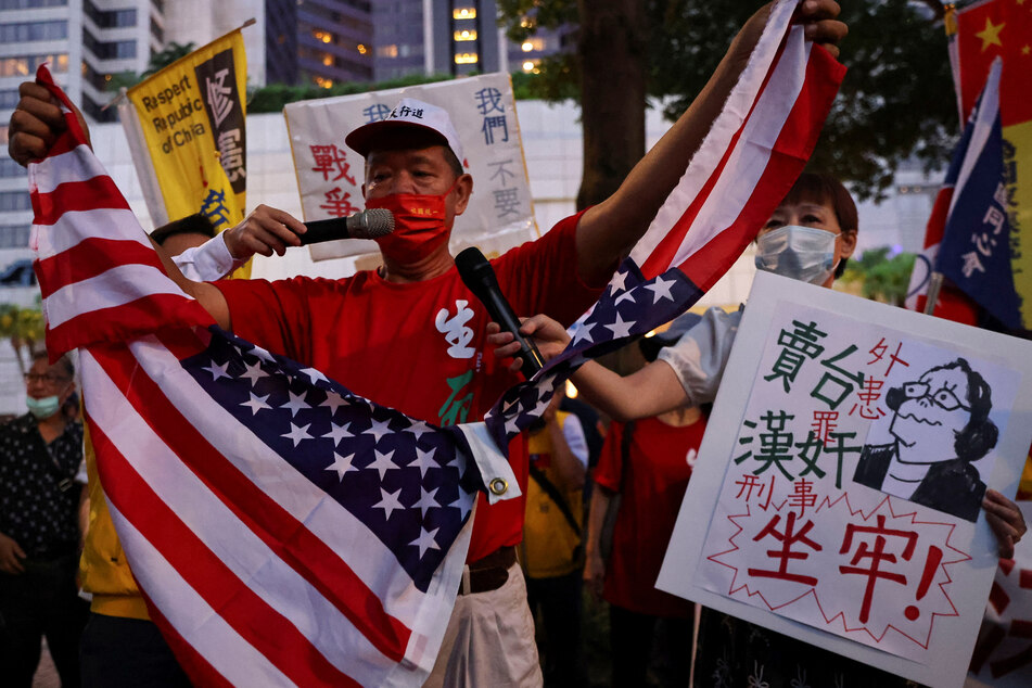 A demonstrator tears a US flag during a protest against Pelosi's visit, in Taipei, Taiwan.