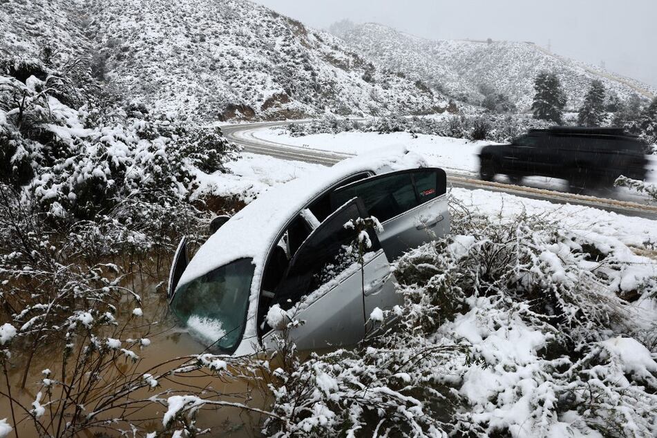 A vehicle skidded off the snowy roadway into a small pond near Green Valley, California, in Los Angeles County.