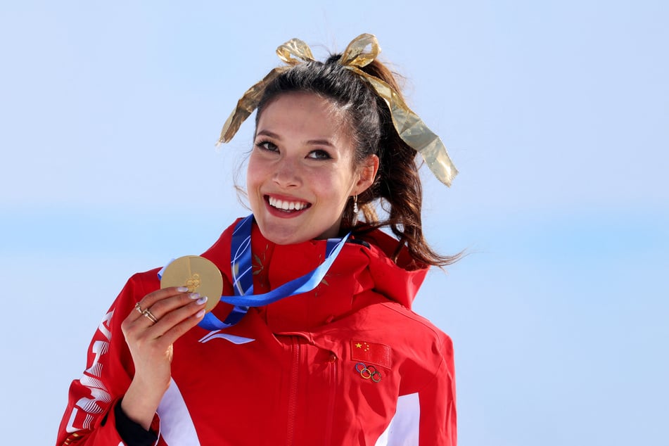 Gold medalist Eileen Gu of China celebrates on the podium after winning the women's freeski halfpipe competition at the Milan-Cortina Olympics on February 22, 2026.