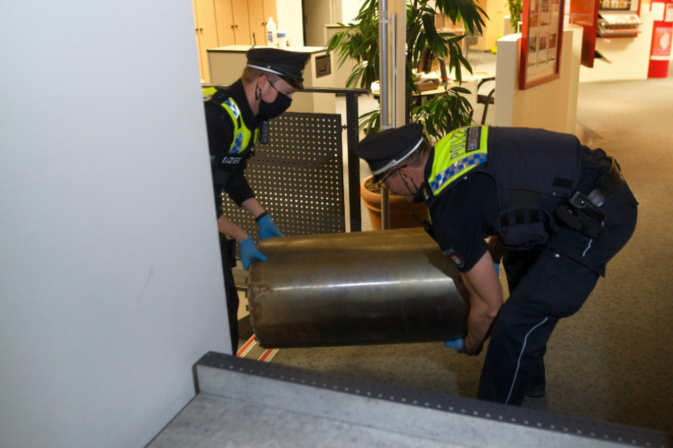 Polizisten tragen den 70-Kilo-Bohraufsatz aus der Bank.