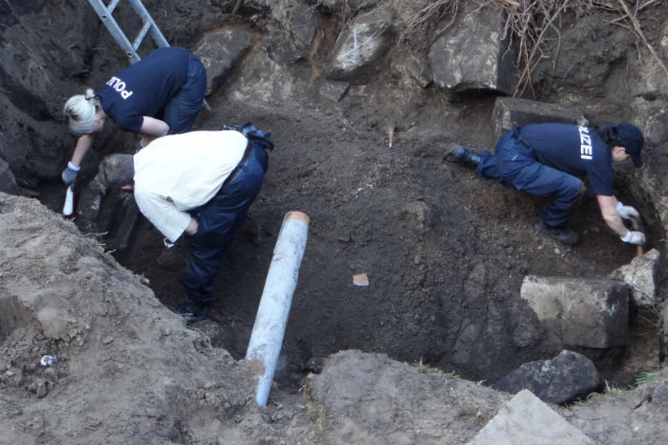 Polizisten graben nach Beweismitteln auf dem ehemaligen Grundstück des mutmaßlichen Täters.