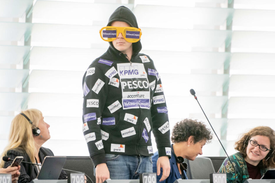 Nico Semsrott überrascht das Europaparlament: Auf seinem Pullover sind Aufkleber von Firmen, die auf die Berateraffäre von Ursula von der Leyen anspielen.