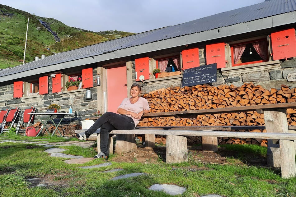 Hüttenwirtin Irmi genießt die Sonne auf der Bank vor der Bortelhütte.