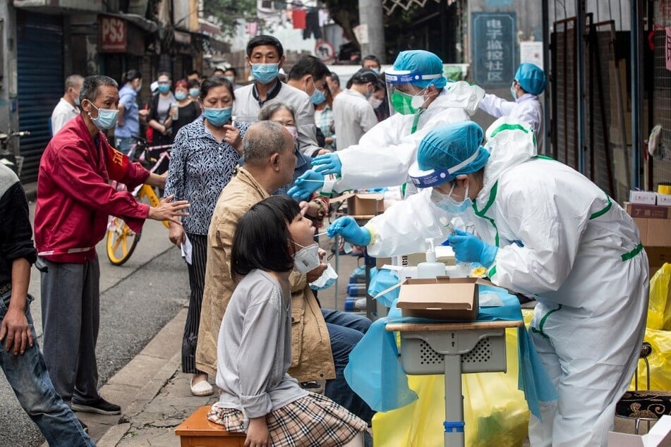 Medical workers take swab samples from residents to be tested for the Covid-19 virus in a street in Wuhan in China's central Hubei province on May 15, 2020.